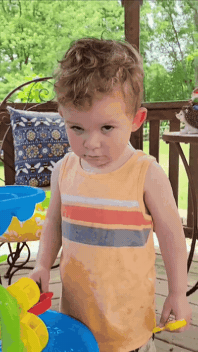 Young Boy Playing With Toy Water Fountain On Porch GIF