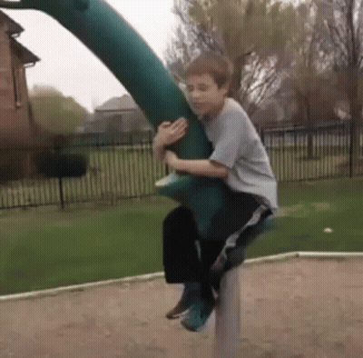 Young Boy Riding Green Dinosaur GIF
