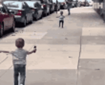 Young Boy Riding Scooter Arms Outstretched GIF