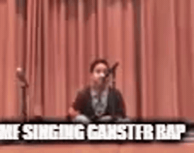 Young Boy Singing Into Microphone On Stage GIF