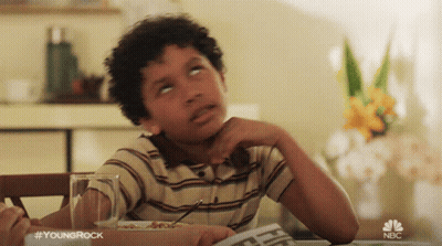 Young Boy Sitting At Table With Newspaper And NBC Logo GIF