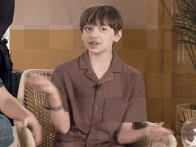 Young Boy Sitting In Chair With Hands Outstretched GIF