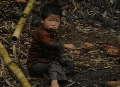 Young Boy Sitting In Dirt Holding Saw GIF