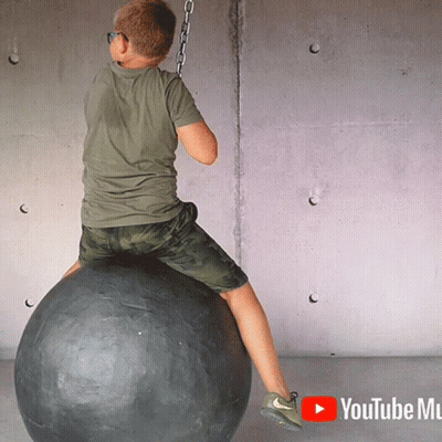 Young Boy Sitting On Black Ball With YouTube Mu GIF
