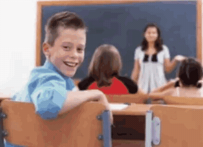 Young Boy Smiling In Classroom With Teacher GIF