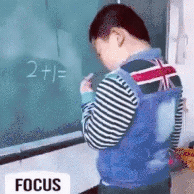 Young Boy Standing In Front Of Blackboard GIF