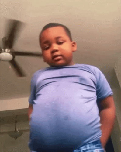 Young Boy Standing In Front Of Ceiling Fan GIF