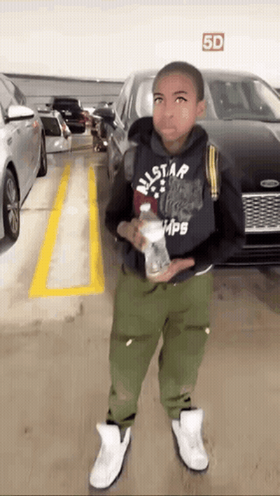 Young Boy Standing In Parking Garage With Bottle Of Water GIF