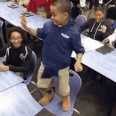 Young Boy Standing On Chair In Classroom GIF