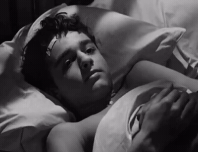 Young Boy With Bandage On Forehead Lying In Bed GIF