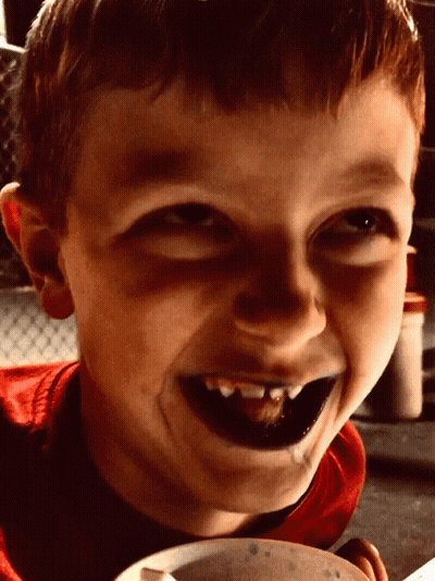 Young Boy With Black Teeth Smiling Holding Bowl Of Food GIF