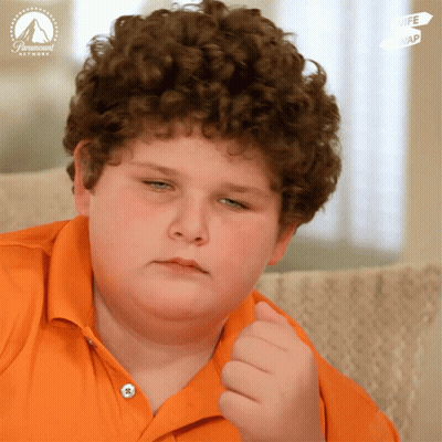 Young Boy With Curly Hair Sitting In Front Of Paramount Network Sign GIF
