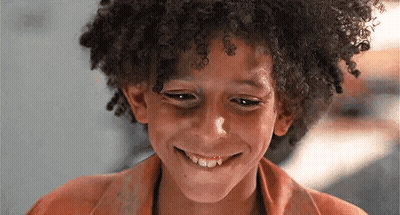 Young Boy With Curly Hair Smiling Looking Down GIF