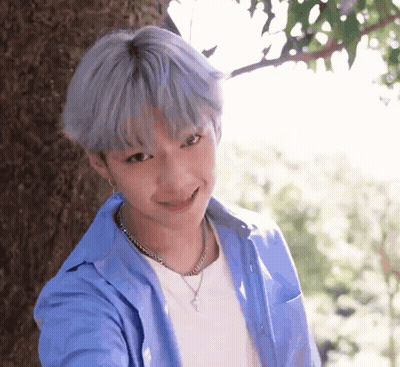 Young Boy With Gray Hair Smiling Next To Tree GIF