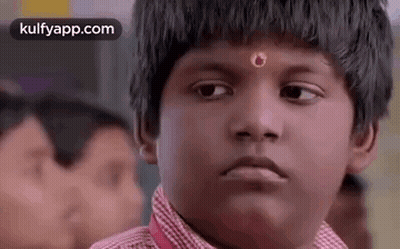 Young Boy With Red Flower Making Funny Face in Classroom
