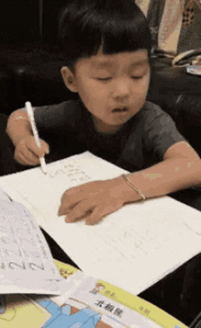 Young Boy Writing At Table GIF