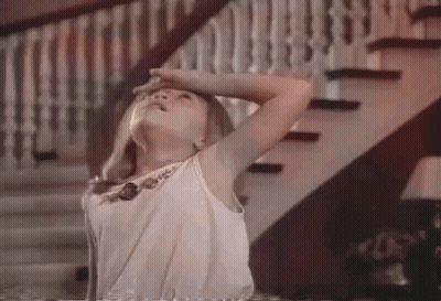Young Girl Holding Head In Front Of Stairs GIF