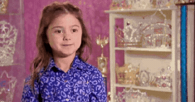Young Girl In Blue Shirt With Crown Shelf GIF