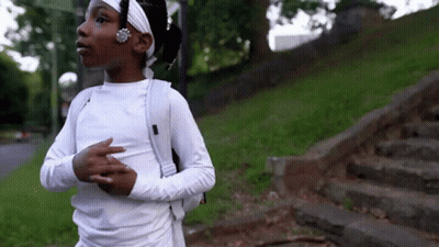 Young Girl In Headband And White Shirt On Stairs GIF