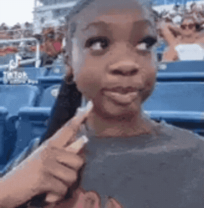 Young Girl In Stadium Pointing Stick At Face GIF