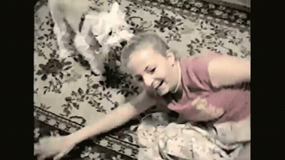 Young Girl Laying On Floor With White Dog GIF