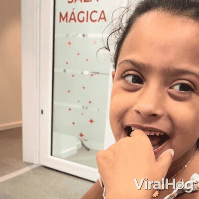Young Girl Looking At Camera With Sala Magica Sign GIF
