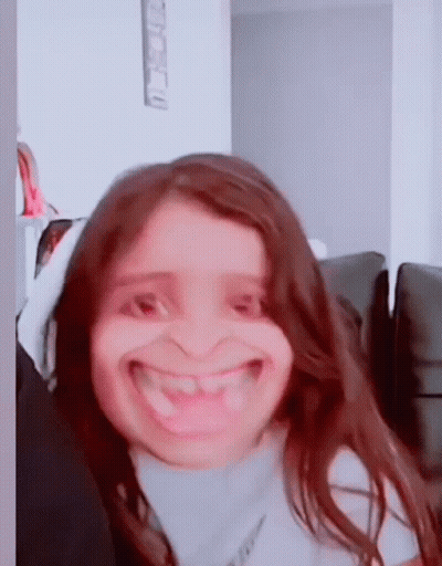 Young Girl Making Funny Face On Couch GIF