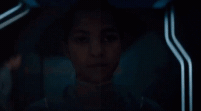 Young Girl Sitting In Dark Room Looking GIF