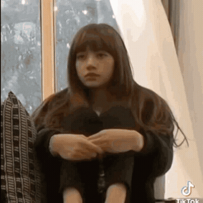 Young Girl Sitting On Couch With Legs Crossed GIF
