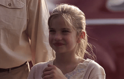 Young Girl Smiling In White Shirt With Blue Embroidery GIF
