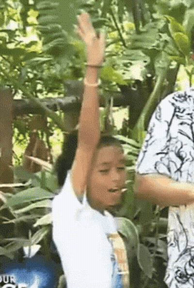 Young Girl Standing In Woods With Arm Up GIF
