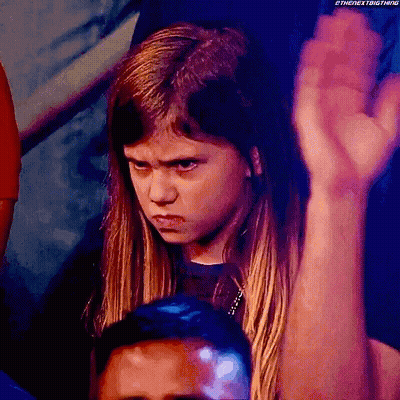 Young Girl With Serious Look Holding Fist Up GIF
