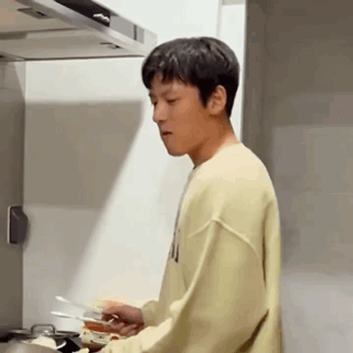 Young Man Cooking In Kitchen In Yellow Sweatshirt GIF