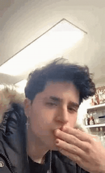 Young Man Covering Mouth While Eating GIF