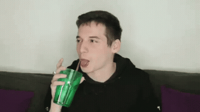 Young Man Drinking Through Straw From Green Cup GIF