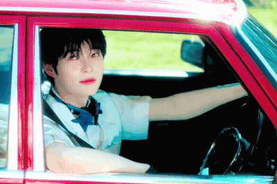 Young Man Driving Red Car Looking Out Window GIF
