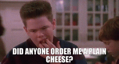 Young Man Eating Cheese Talking To Another Man GIF