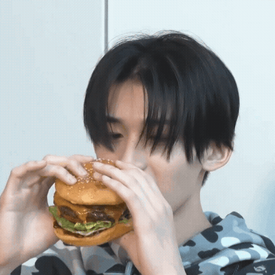 Young Man Eating Large Sesame Hamburger GIF
