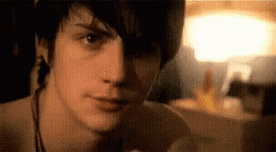 Young Man Face In Dark Room With Lamp GIF
