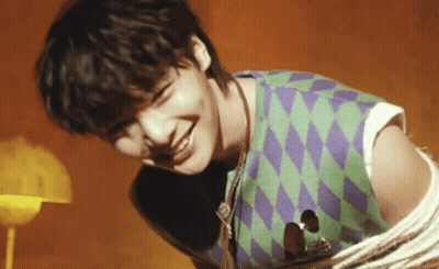 Young Man Holding Guitar Smiling Green Purple Vest GIF