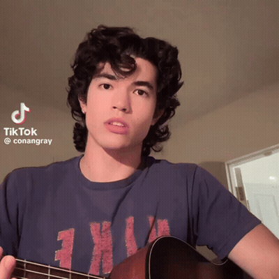 Young Man Holding Guitar With TikTok Watermark GIF
