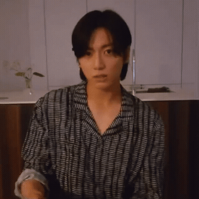Young Man Holding Microphone In Striped Shirt GIF