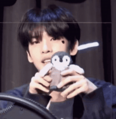 Young Man Holding Stuffed Penguin GIF