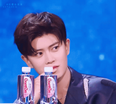 Young Man Holding Two Bottles Of Ganten Water GIF