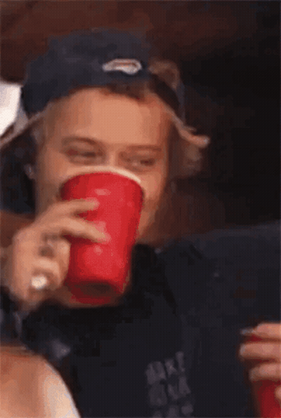 Young Man In Baseball Cap Holding Red Cup GIF