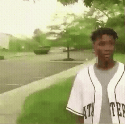 Young Man In Baseball Jersey On Sidewalk GIF