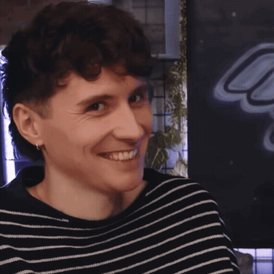 Young Man In Black And White Striped Sweater Smiling GIF