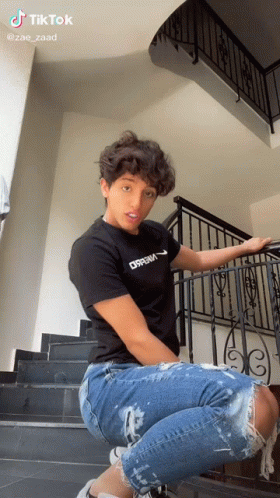 Young Man In Black Dream Shirt On Stairs GIF