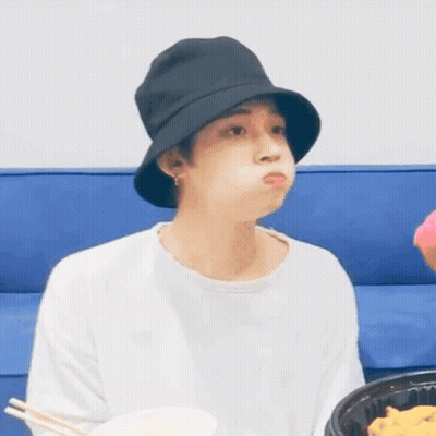 Young Man In Black Hat Eating On Blue Couch GIF