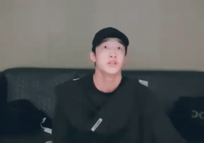 Young Man In Black Hat Sitting On Couch GIF